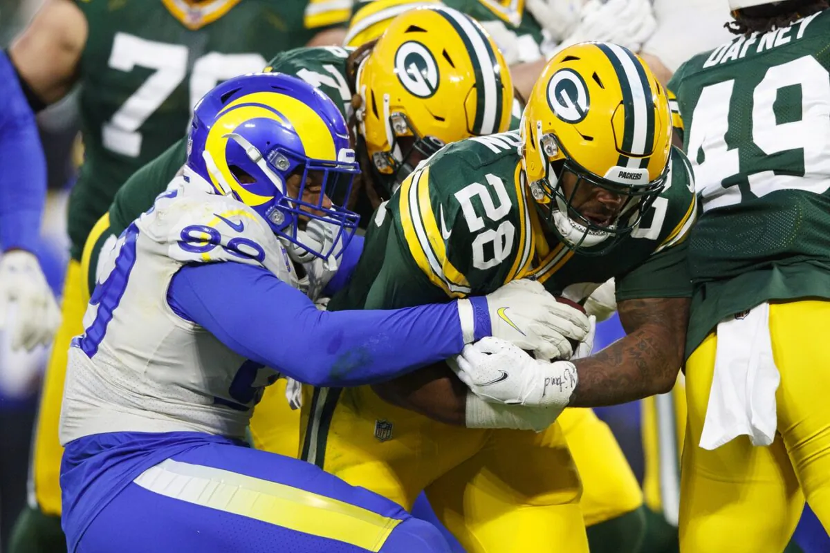 Green Bay Packers running back AJ Dillon (28) is tackled by Los Angeles Rams defensive tackle Aaron Donald (99) during the second quarter at Lambeau Field in Green Bay, Wis., on Nov. 28, 2021. (Jeff Hanisch/USA TODAY Sports via Field Level Media)