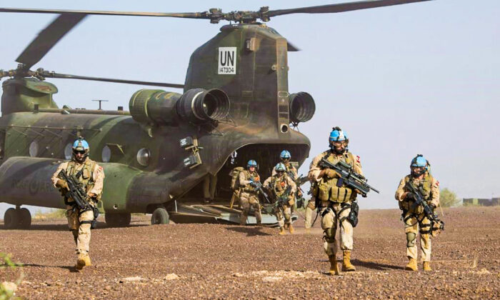 Canadian infantry and medical personnel disembark a Chinook helicopter as they take part in a medical evacuation demonstration on the United Nations base in Gao, Mali, December 22, 2018. (The Canadian Press/Adrian Wyld)