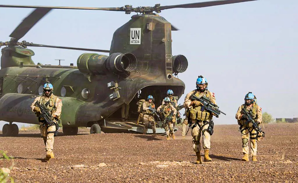 Canadian infantry and medical personnel disembark a Chinook helicopter as they take part in a medical evacuation demonstration on the United Nations base in Gao, Mali, December 22, 2018. (The Canadian Press/Adrian Wyld)