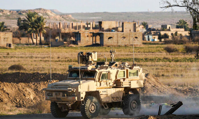 A US military vehicle drives through the Syrian village of Baghuz in the countryside of the eastern Deir Ezzor Province on Jan. 26, 2019. (Delil Souleiman/AFP/Getty Images)