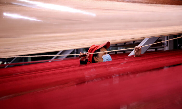 A worker produces carpets that will be exported at a factory in China's eastern Shandong Province on Oct. 20, 2021. (STR/AFP via Getty Images)