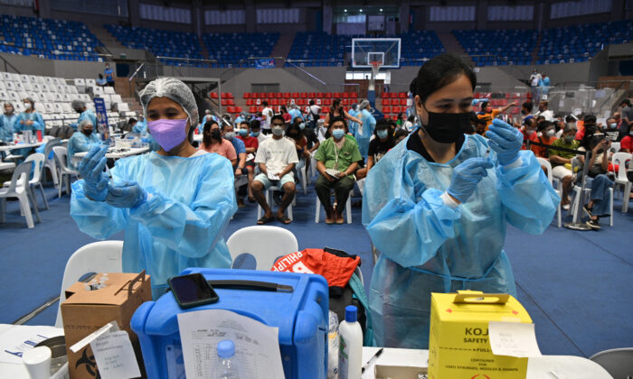 Medical workers prepare COVID-19 coronavirus vaccines at a colisium in Makati City, suburban Manila, Philippines, on Nov. 29, 2021. (TED ALJIBE/AFP via Getty Images)