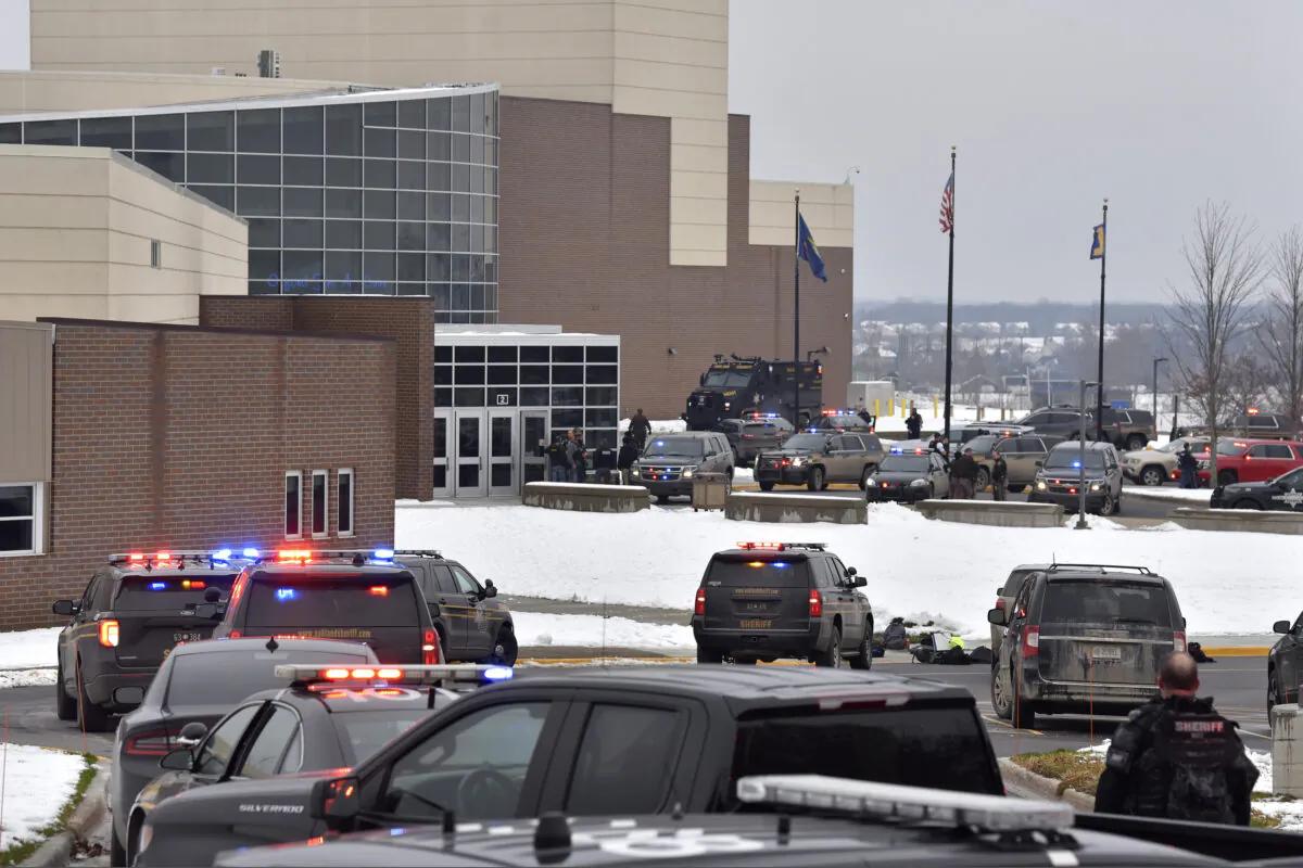 Dozens of police, fire, and EMS personnel work on the scene of a shooting at Oxford High School in Oxford Township, Mich., on Nov. 30, 2021. (Todd McInturf/The Detroit News via AP)