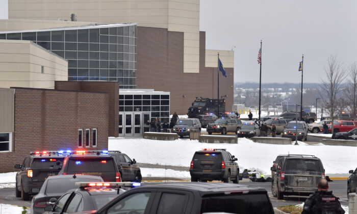 Dozens of police, fire, and EMS personnel work on the scene of a shooting at Oxford High School in Oxford Township, Mich., on Nov. 30, 2021. (Todd McInturf/The Detroit News via AP)