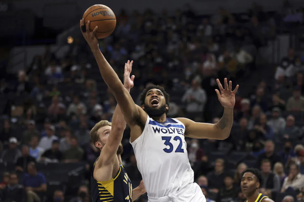 Minnesota Timberwolves center Karl-Anthony Towns (32) shoots the ball against Indiana Pacers forward Domantas Sabonis (11) during the first half of an NBA basketball game in Minneapolis on Nov. 29, 2021. (Stacy Bengs/AP Photo)