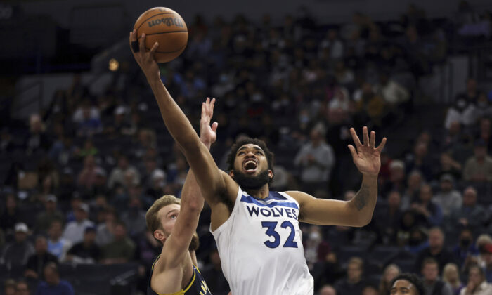 Minnesota Timberwolves center Karl-Anthony Towns (32) shoots the ball against Indiana Pacers forward Domantas Sabonis (11) during the first half of an NBA basketball game in Minneapolis on Nov. 29, 2021. (Stacy Bengs/AP Photo)