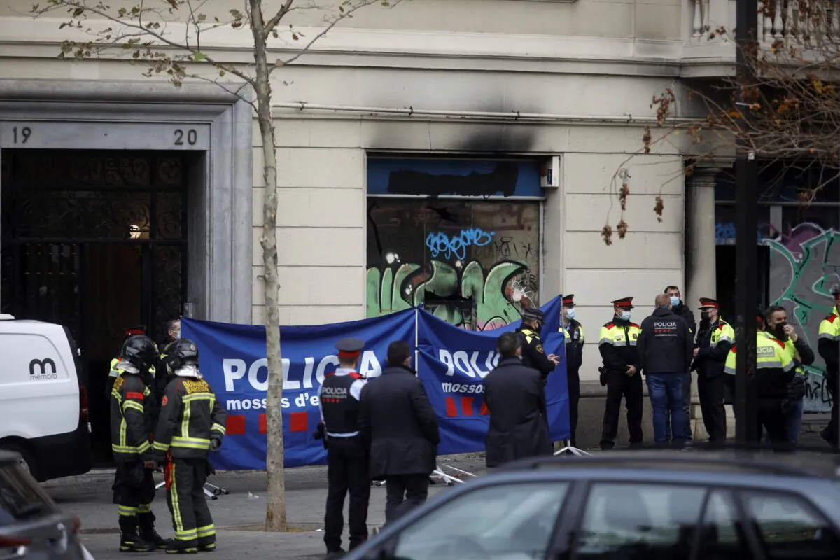 Policemen and firefighters work at the scene where a fire broke out in a building, in Barcelona, Spain, on Nov. 30, 2021. (Kike Rincon/Europa Press via AP)