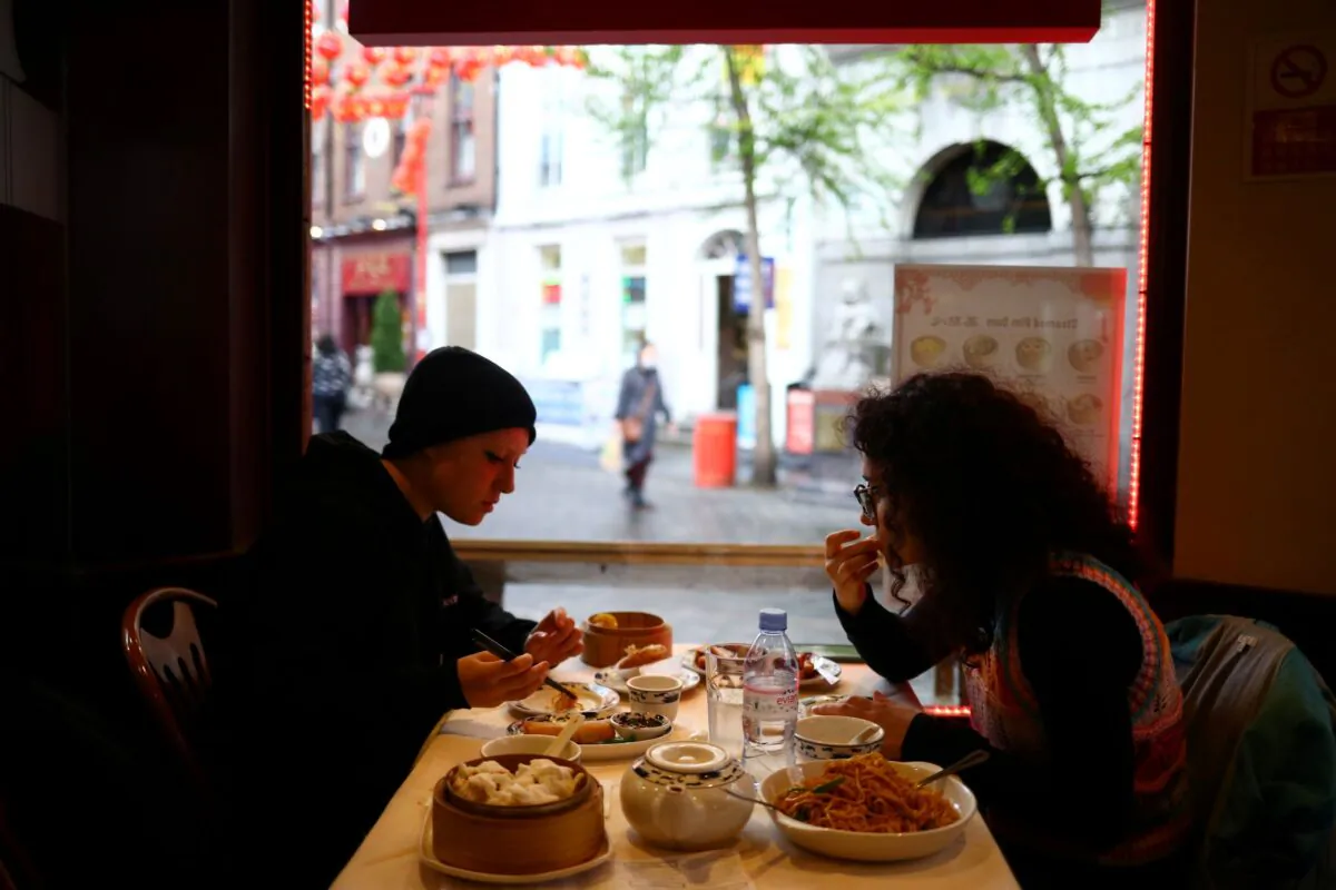 People sit inside a restaurant, amid the outbreak of the coronavirus disease (COVID-19), in Chinatown, London, Britain, on May 18, 2021. (Hannah McKay/Reuters)