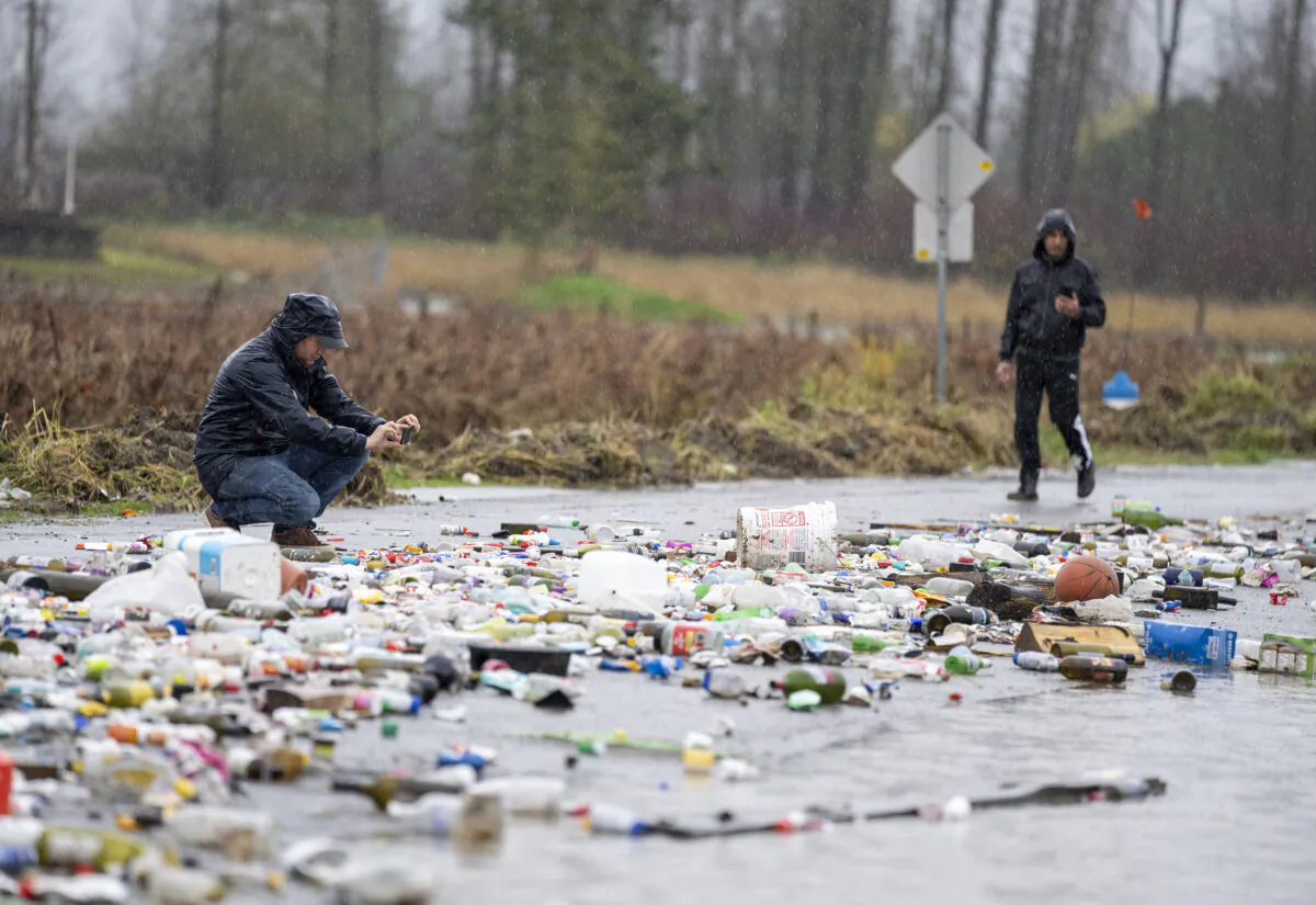 Debris from receding flood waters is pictured along a road as heavy rains form an atmospheric river continue in Abbotsford, B.C., November 30, 2021. (The Canadian Press/Jonathan Hayward)