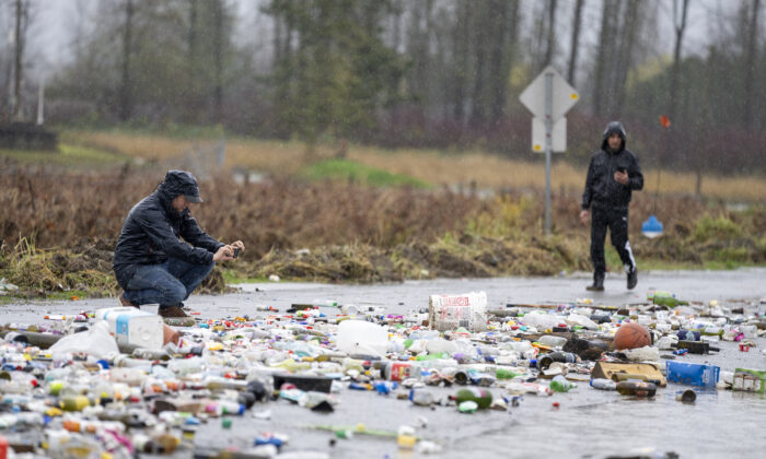 Debris from receding flood waters is pictured along a road as heavy rains form an atmospheric river continue in Abbotsford, B.C., November 30, 2021. (The Canadian Press/Jonathan Hayward)