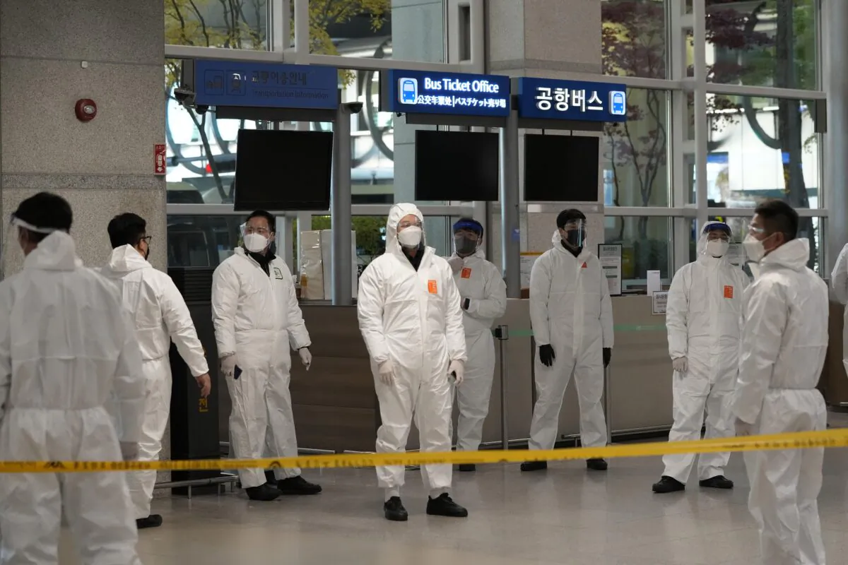 Quarantine officers wait to guide travelers at the arrival hall of the Incheon International Airport in Incheon, South Korea, on Dec. 1, 2021. (Ahn Young-joon/AP Photo)