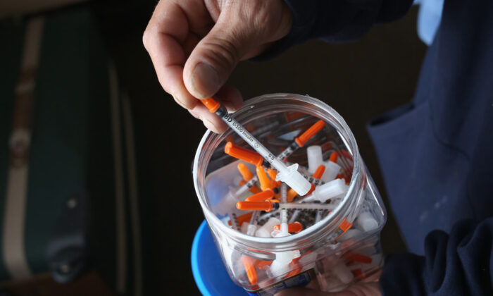 A drug user takes a needle before injecting himself with heroin in New London, Connecticut on March 23, 2016. (John Moore/Getty Images)