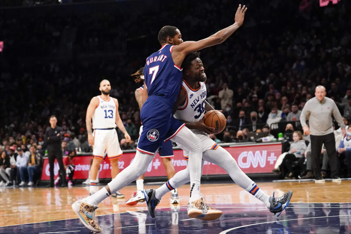 New York Knicks forward Julius Randle (30) drives against Brooklyn Nets forward Kevin Durant (7) during the first half of an NBA basketball game, in New York, on Nov. 30, 2021. (Mary Altaffer/AP Photo)