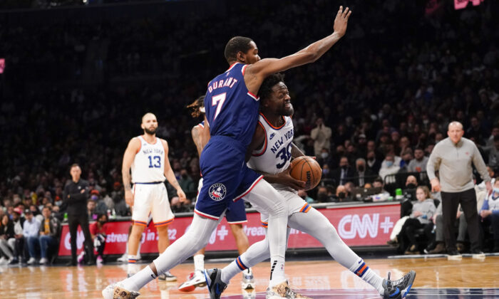 New York Knicks forward Julius Randle (30) drives against Brooklyn Nets forward Kevin Durant (7) during the first half of an NBA basketball game, in New York, on Nov. 30, 2021. (Mary Altaffer/AP Photo)