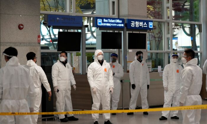 Quarantine officers wait to guide travelers at the arrival hall of the Incheon International Airport in Incheon, South Korea, on Dec. 1, 2021. (Ahn Young-joon/AP Photo)
