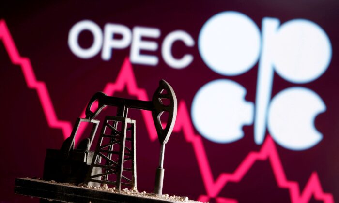 A 3D-printed oil pump jack is seen in front of the OPEC logo in this illustration picture taken on April 14, 2020. (Dado Ruvic/Reuters)