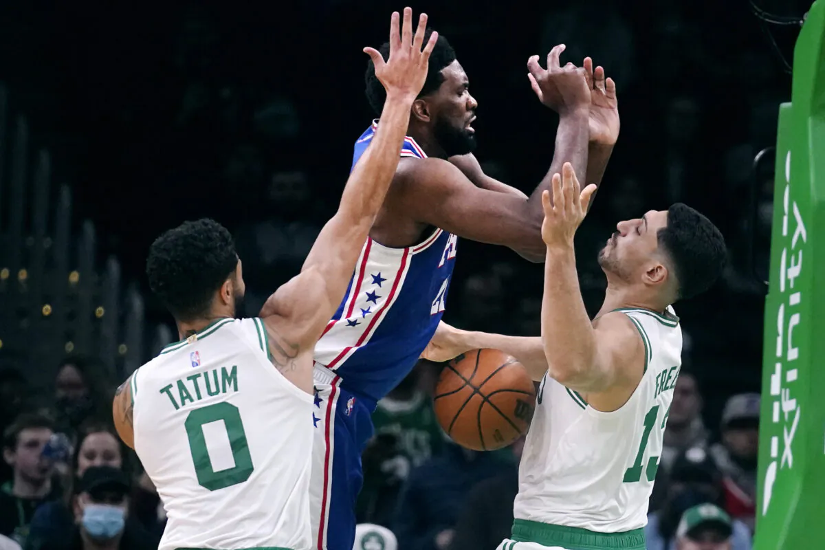 Philadelphia 76ers center Joel Embiid (C) loses control of the ball against Boston Celtics center Enes Kanter Freedom (R) and forward Jayson Tatum (0) during the first half of an NBA basketball game, in Boston, on Dec. 1, 2021. (Charles Krupa/AP Photo)