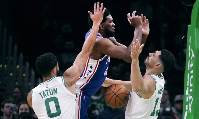 Philadelphia 76ers center Joel Embiid (C) loses control of the ball against Boston Celtics center Enes Kanter Freedom (R) and forward Jayson Tatum (0) during the first half of an NBA basketball game, in Boston, on Dec. 1, 2021. (Charles Krupa/AP Photo)