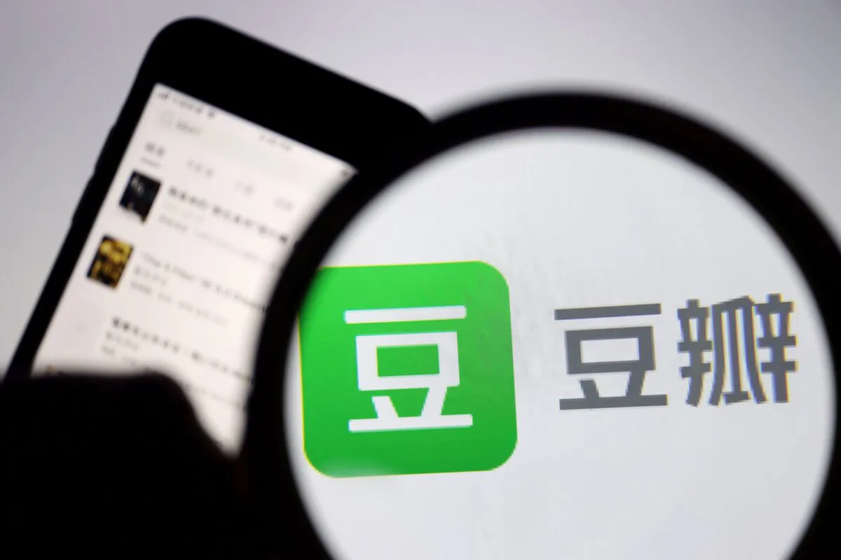 The logo of Chinese social networking forum Douban is seen under a magnifying glass near a mobile phone displaying the Douban app, on April 14, 2021. (Florence Lo/Reuters)
