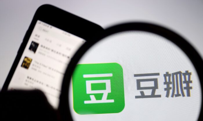 The logo of Chinese social networking forum Douban is seen under a magnifying glass near a mobile phone displaying the Douban app, on April 14, 2021. (Florence Lo/Reuters)