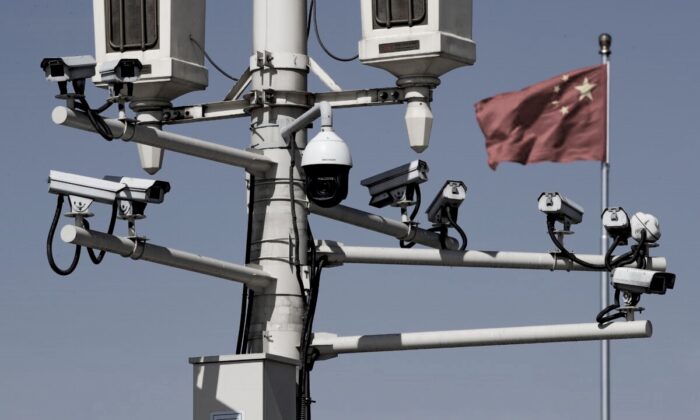 A Chinese national flag flutters near the surveillance cameras mounted on a lamppost in Tiananmen Square in Beijing, on March 15, 2019. (Andy Wong/AP Photo)