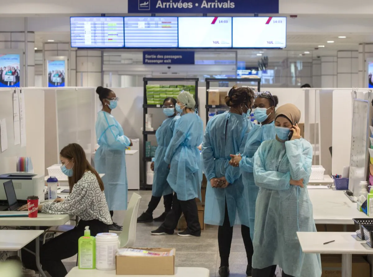 Healthcare workers wait for airline passengers at a COVID-19 testing center at Trudeau Airport in Montreal, on Feb. 19, 2021. (The Canadian Press/Ryan Remiorz)
