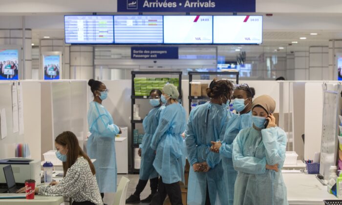 Healthcare workers wait for airline passengers at a COVID-19 testing center at Trudeau Airport in Montreal, Feb. 19, 2021. (The Canadian Press/Ryan Remiorz)