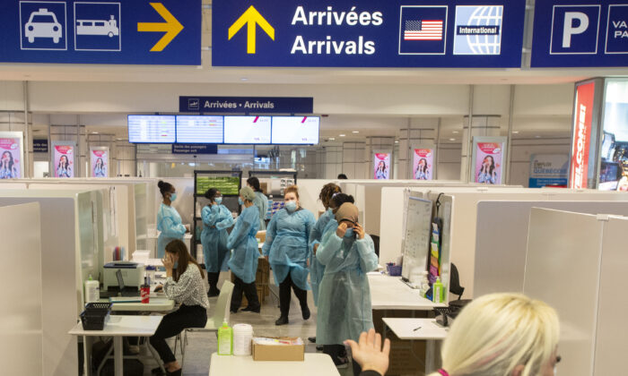 Healthcare workers wait for airline passengers at a COVID-19 testing center at Trudeau Airport in Montreal on Feb. 19, 2021. (The Canadian Press/Ryan Remiorz)