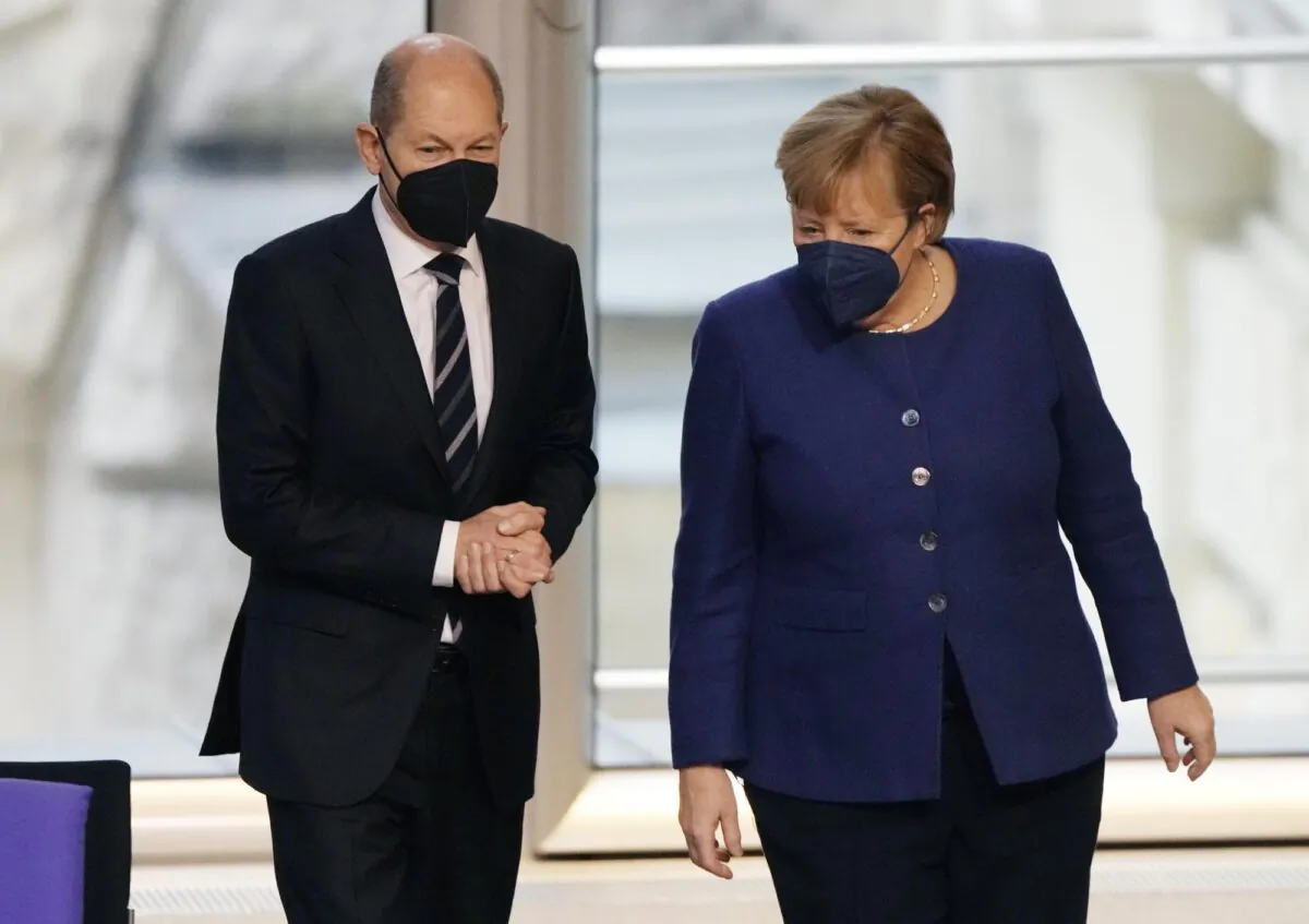 German Chancellor Angela Merkel, right, and SPD candidate for chancellor Olaf Scholz talk during a Bundestag session about new COVID-19 measures at the Reichstag building in Berlin on Nov. 18, 2021. (Markus Schreiber/AP Photo)