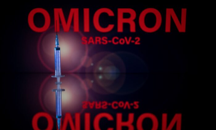 A syringe and a screen displaying Omicron, the name of the COVID-19 variant, on Dec. 1, 2021. (Lionel Bonaventure/AFP via Getty Images)