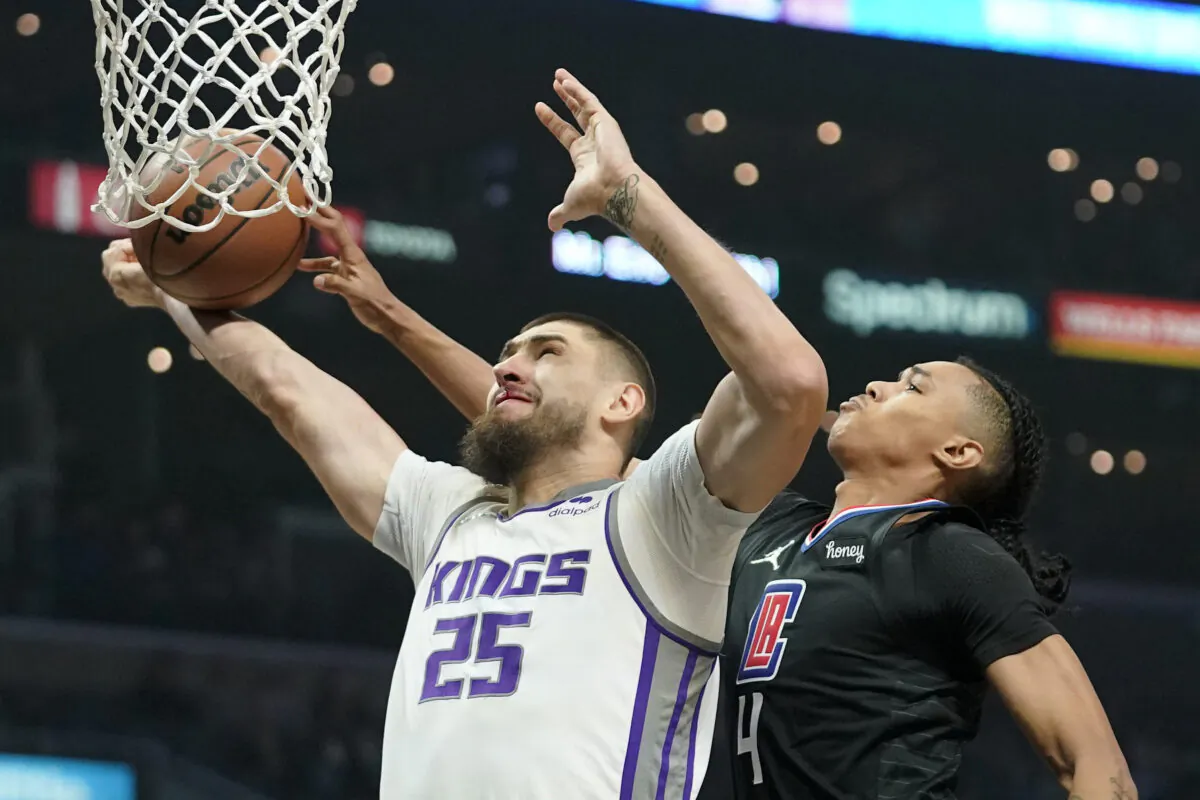 Sacramento Kings center Alex Len, left, shoots as Los Angeles Clippers guard Brandon Boston Jr. defends during the first half of an NBA basketball game in Los Angeles on Dec. 1, 2021. (AP Photo/Mark J. Terrill)