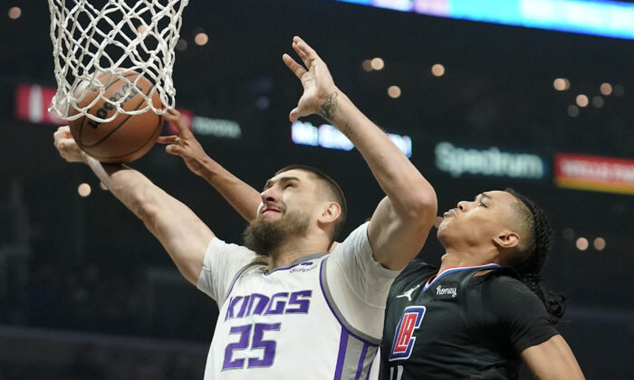 Sacramento Kings center Alex Len, left, shoots as Los Angeles Clippers guard Brandon Boston Jr. defends during the first half of an NBA basketball game in Los Angeles on Dec. 1, 2021. (AP Photo/Mark J. Terrill)