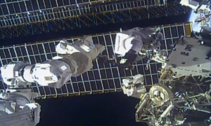 Astronaut Tom Marshburn replaces a broken antenna outside the International Space Station after getting NASA's all-clear for orbiting debris, on Dec. 2, 2021. (NASA via AP)