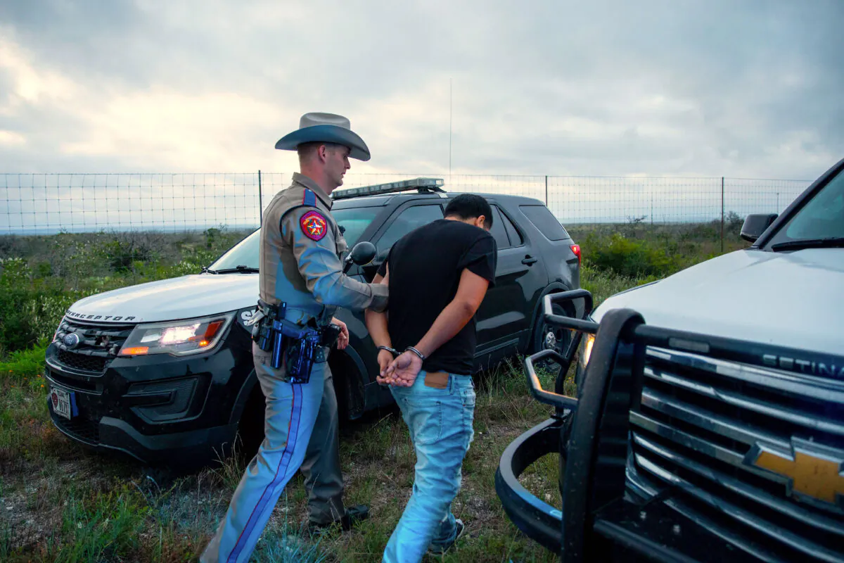 A Texas state trooper arrests a U.S. citizen who was transporting three illegal aliens to San Antonio, in Kinney County, Texas, on Oct. 20, 2021. (Charlotte Cuthbertson/The Epoch Times)