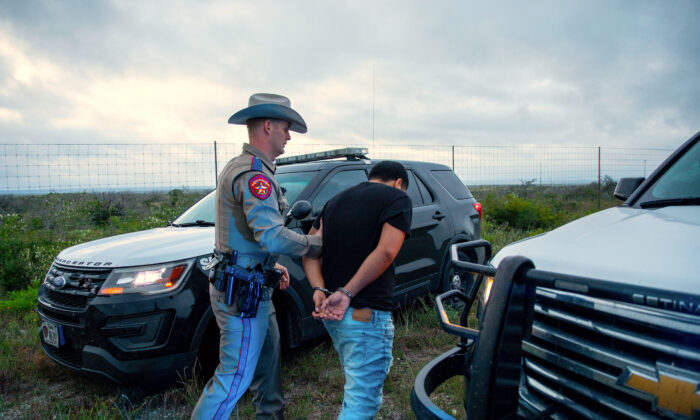 A Texas state trooper arrests a U.S. citizen who was transporting three illegal aliens to San Antonio, in Kinney County, Texas, on Oct. 20, 2021. (Charlotte Cuthbertson/The Epoch Times)