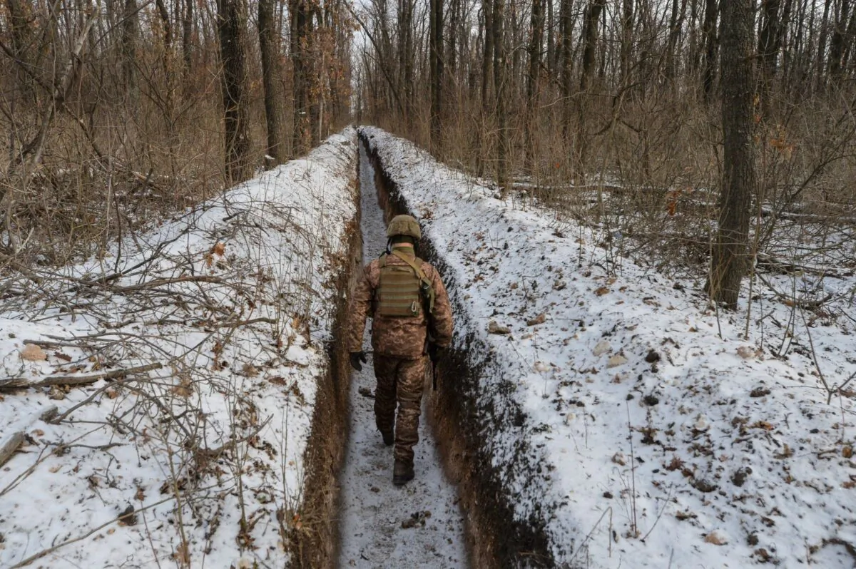 A Ukrainian service member walks along fighting positions on the contact line with Russian-backed separatist rebels near the town of Avdiivka in Donetsk Region, Ukraine, on Feb. 13, 2021. (Oleksandr Klymenko/Reuters)