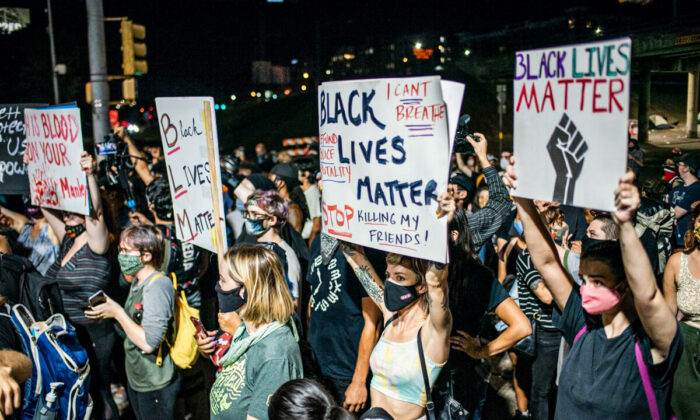 People hold up signs outside Austin Police Department after a vigil for Garrett Foster, a Black Lives Matter protester who was shot dead after allegedly brandishing his firearm at a driver, in Austin, Texas, on July 26, 2020. (Sergio Flores/Getty Images)
