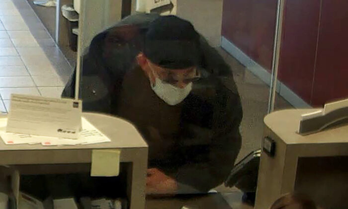 In this image taken from bank surveillance video and released by the City of Clearwater-Public Safety, David Marc Ratcliff approaches a teller at a Wells Fargo bank as he robs the bank in Clearwater, Fla., on Nov. 30, 2021. (City of Clearwater-Public Safety via AP)