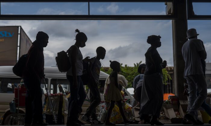 Passengers line up to board a taxi in Soweto, South Africa on Dec. 2, 2021. (Jerome Delay/AP Photo)