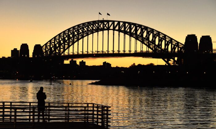 A man looks out to the Sydney Harbour Bridge at dawn in Sydney, Australia, July 27, 2021. (AAP Image/Mick Tsikas)