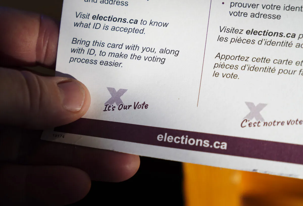 A person holds an Elections Canada voter information card after receiving it in the mail on Aug. 31, 2021. (Sean Kilpatrick/The Canadian Press)