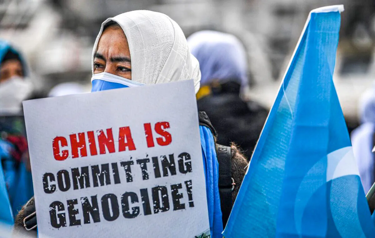 Members of Women Muslim Uighur minority hold placards and flag of east Turkestan as they demonstrate to ask for news of their relatives and to express their concern about the ratification of an extradition treaty between China and Turkey, near China consulate in Istanbul on March 8, 2021 during a International Women Day. (Ozan Kose/AFP via Getty Images)