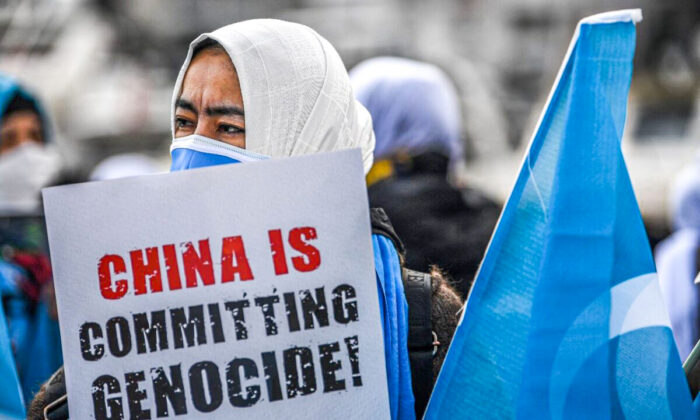 Members of Women Muslim Uighur minority hold placards and flag of east Turkestan as they demonstrate to ask for news of their relatives and to express their concern about the ratification of an extradition treaty between China and Turkey, near China consulate in Istanbul on March 8, 2021 during a International Women Day. (Ozan Kose/AFP via Getty Images)