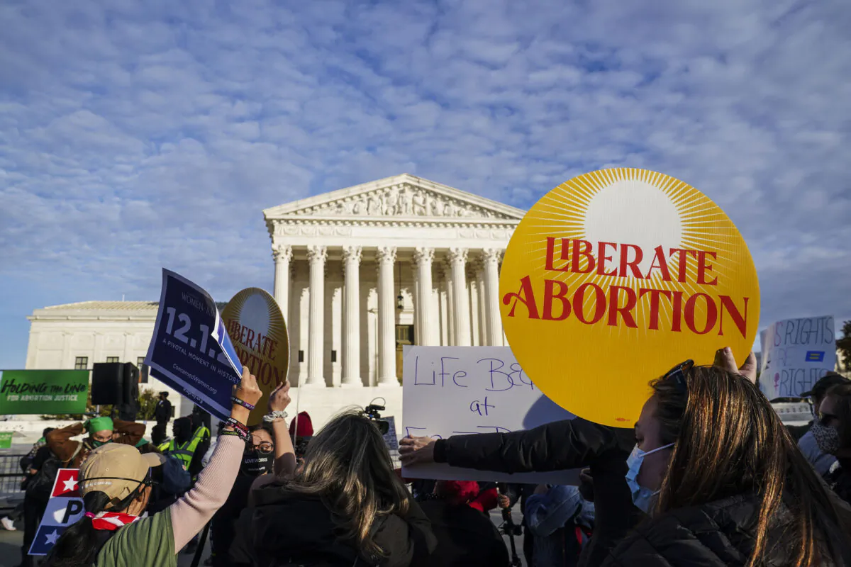 Participants hold signs during the march "Hold The Line For Abortion Justice" at the U.S. Supreme Court in Washington on Dec. 1, 2021. (Leigh Vogel/Getty Images for Women's March Inc)