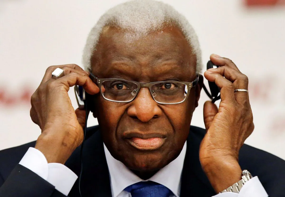 Lamine Diack adjusts his headphones during a joint IOC and IAAF news conference on the site of the World Athletic Championships in Beijing, China, on Aug. 21, 2015. (Kin Cheung/AP Photo)