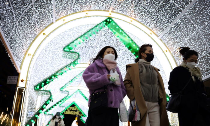 People walk under a Christmas light display at a shopping district in central Seoul, South Korea, on Dec. 1, 2021. (Kim Hong-ji/Reuters)