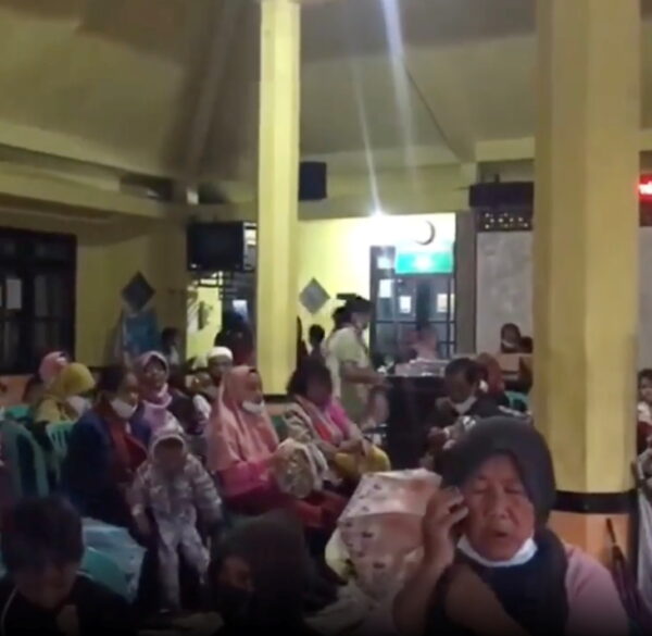 People wait at an evacuation center in Candipuro following the eruption of Indonesia's Semeru volcano