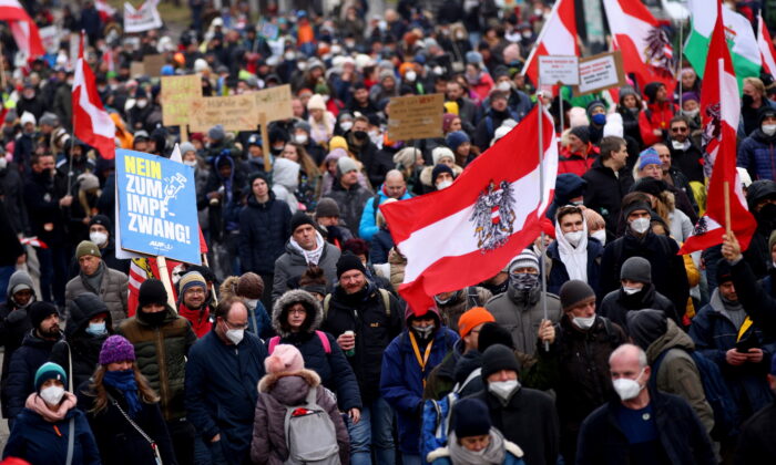 Demonstrators hold flags and placards as they march to protest against COVID-19 restrictions and the mandatory vaccination in Vienna, Austria, on Dec. 4, 2021. (Lisi Niesner/Reuters)