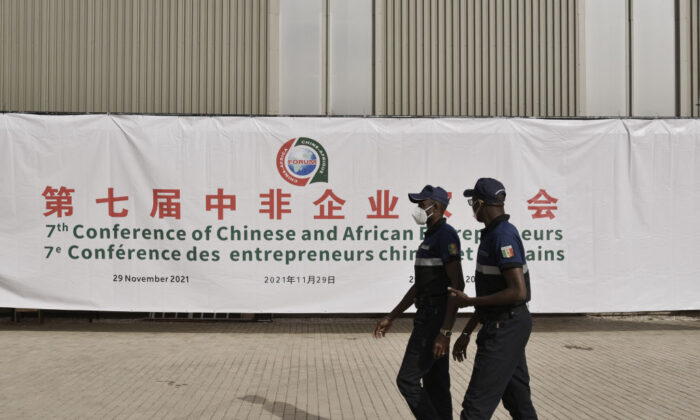 Security officers walk past a banner at the entrance of a conference hall during the China-Africa Cooperation (FOCAC) meeting at the Diamniadio in Dakar, Senegal, on Nov. 29, 2021. (Seyllou/AFP via Getty Images)
