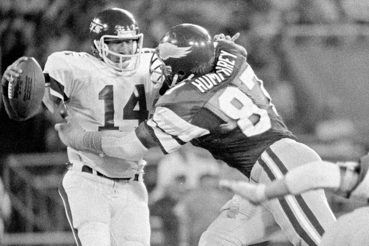 Philadelphia Eagles' Claude Humphrey (87) grabs New York Jets quarterback Richard Todd (14) and pulls him down for an 11-yard loss during an exhibition NFL football game in Philadelphia, on Aug. 15, 1980. (Clem Murray/AP Photo, File)